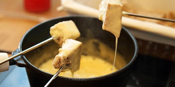 Brood dopen in een pannetje met kaasfondue