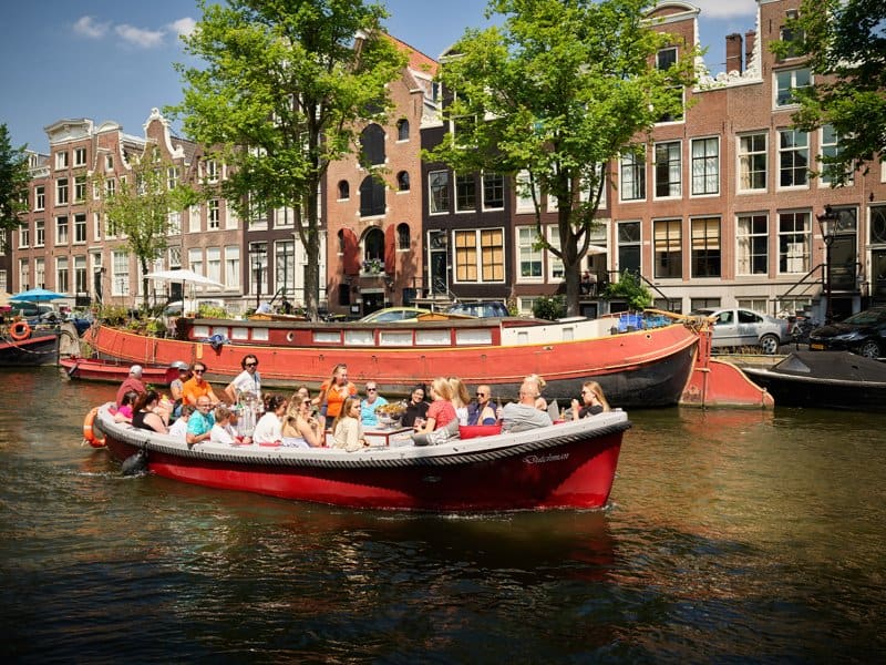 Boot Dutchman sloep met groep mensen in Amsterdamse grachten Boot Dutchman sloep met groep mensen in de Amsterdamse Grachten