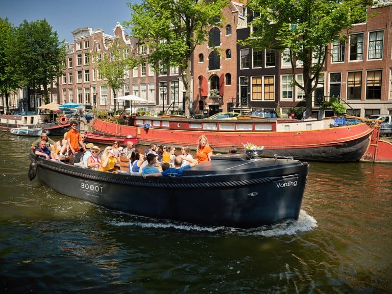 Sloep Vording Boot met schipper kapitein en mensen in amsterdamse grachten Sloep Vording Boot met schipper kapitein en mensen in Amsterdamse grachten