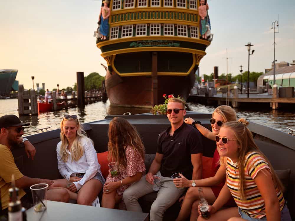 Boottocht tijdens een bedrijfsuitje Mensen in een sloep in Amsterdam