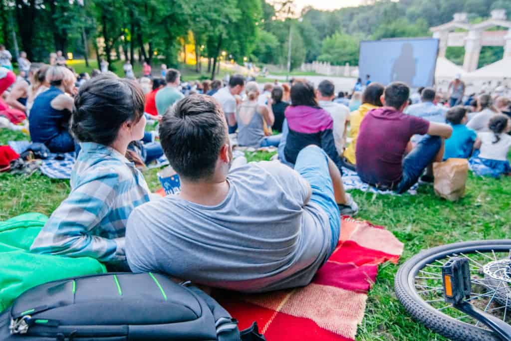 Mensen kijken naar film in openlucht bioscoop Mensen kijken naar een openluchtbioscoop in een park