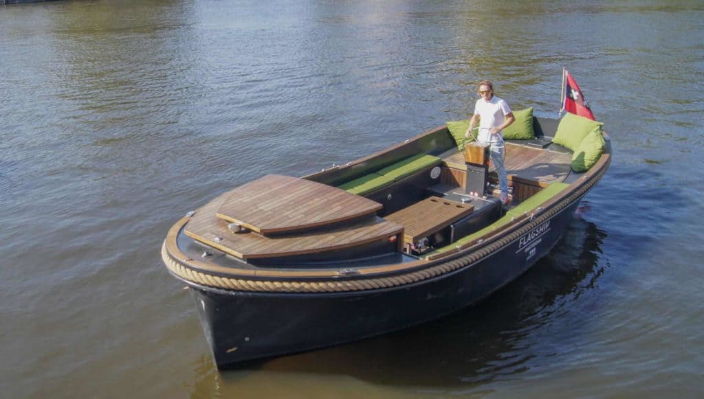 Naut op het water Sloep Naut op het water in Amsterdam bestuurd door een kapitein