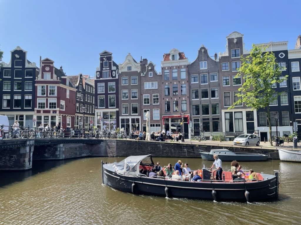 Sloep Amigo Amsterdam Zijaanzicht van sloep Amigo in Amsterdam met mensen op de sloep